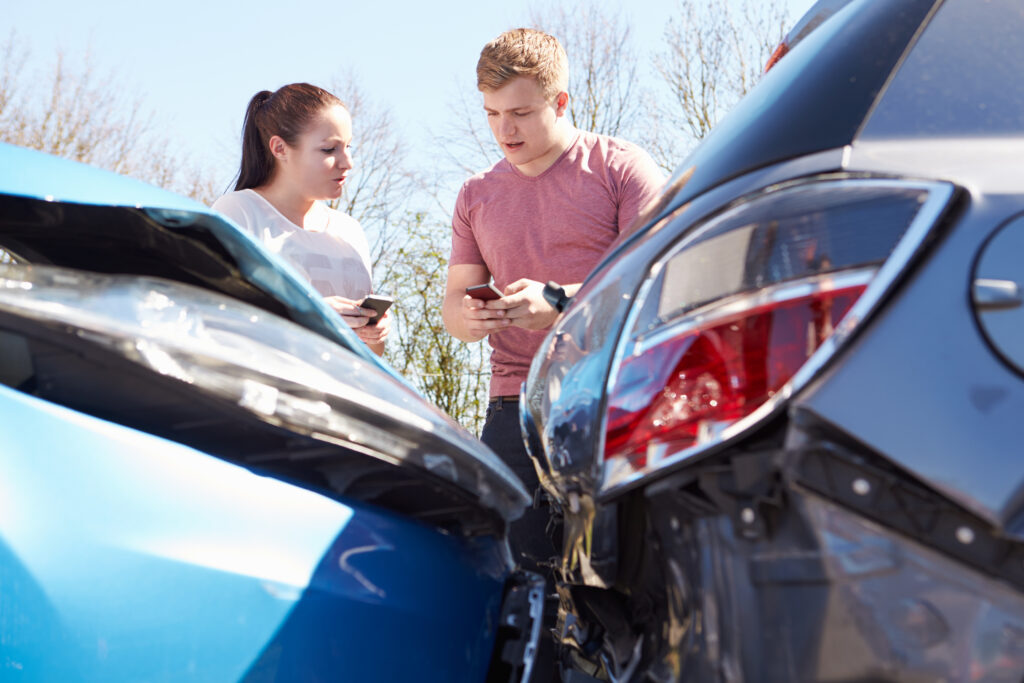 Fahrer tauschen Kontaktdaten nach einem Unfall mit einem Leasing-Auto aus.